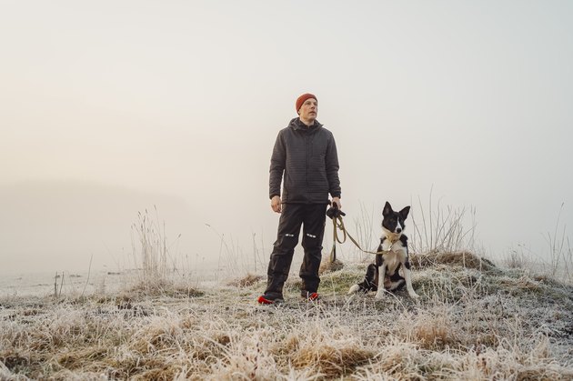 Man and his dog outdoors in rural nature on early morning