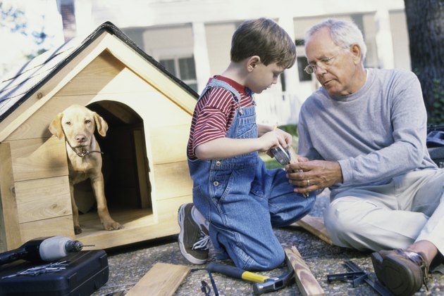 Grandfather and his grandson building a kennel