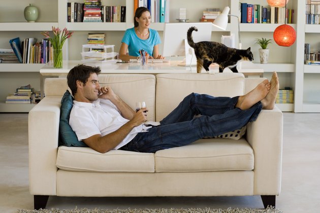 Couple with cat relaxing at home