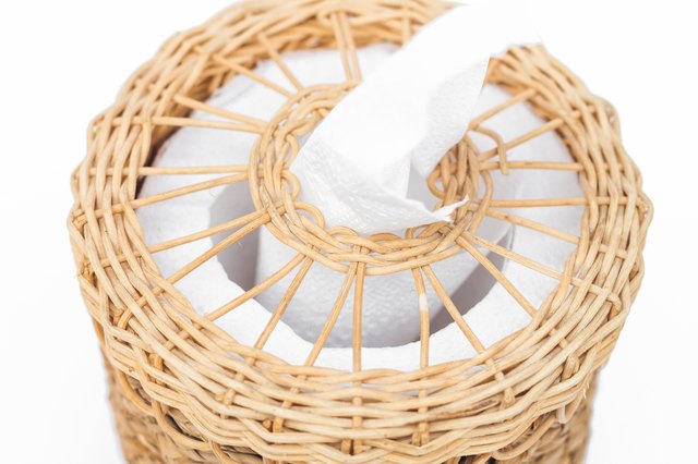 Close-Up Of Tissue Paper In Wicker Basket Against White Background