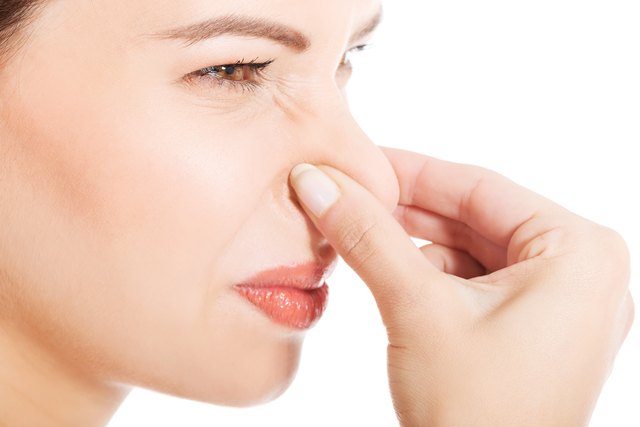 Close-Up Side View Of Mid Adult Woman Holding Nose Against White Background