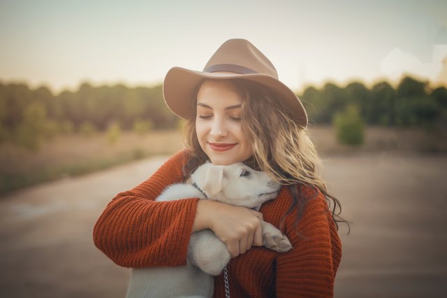 Love woman embracing pet dog in nature
