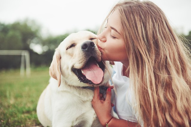 girl kissing her dog