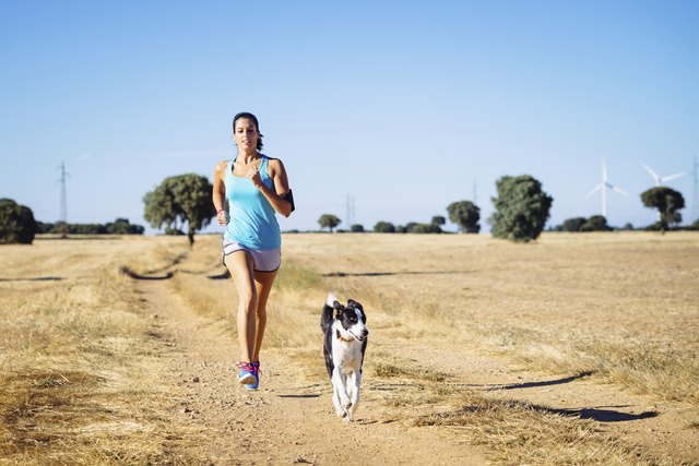 Woman running cross trail in countryside path