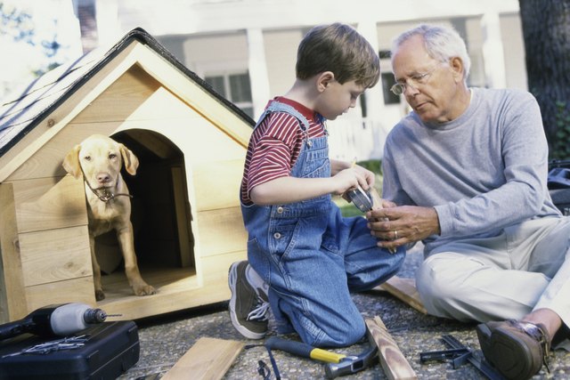 Grandfather and his grandson building a kennel