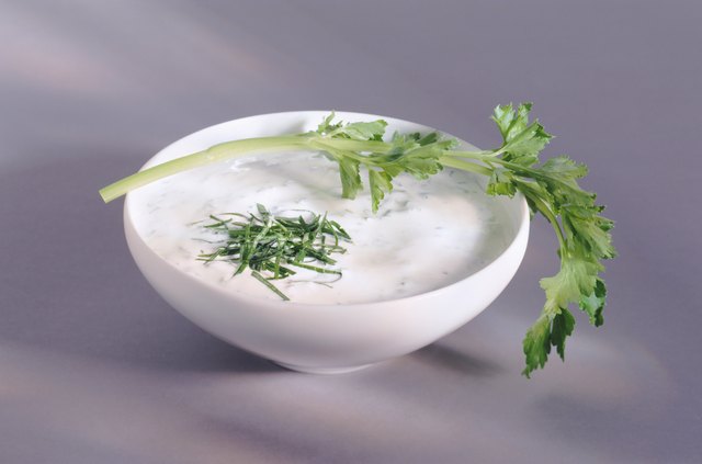 Yoghurt in bowl with leaf, close-up