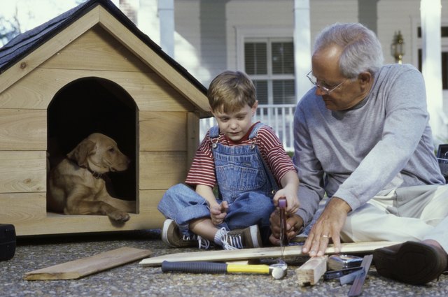 Grandfather and his grandson building a kennel
