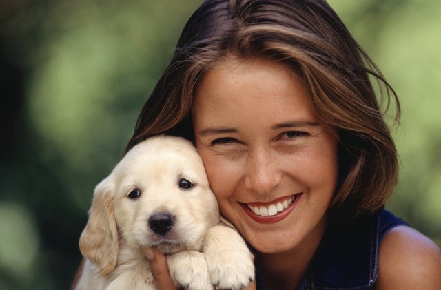 Young woman holding puppy, portrait