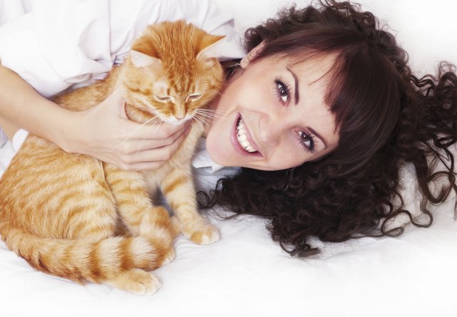 Joyful girl hugging red cat